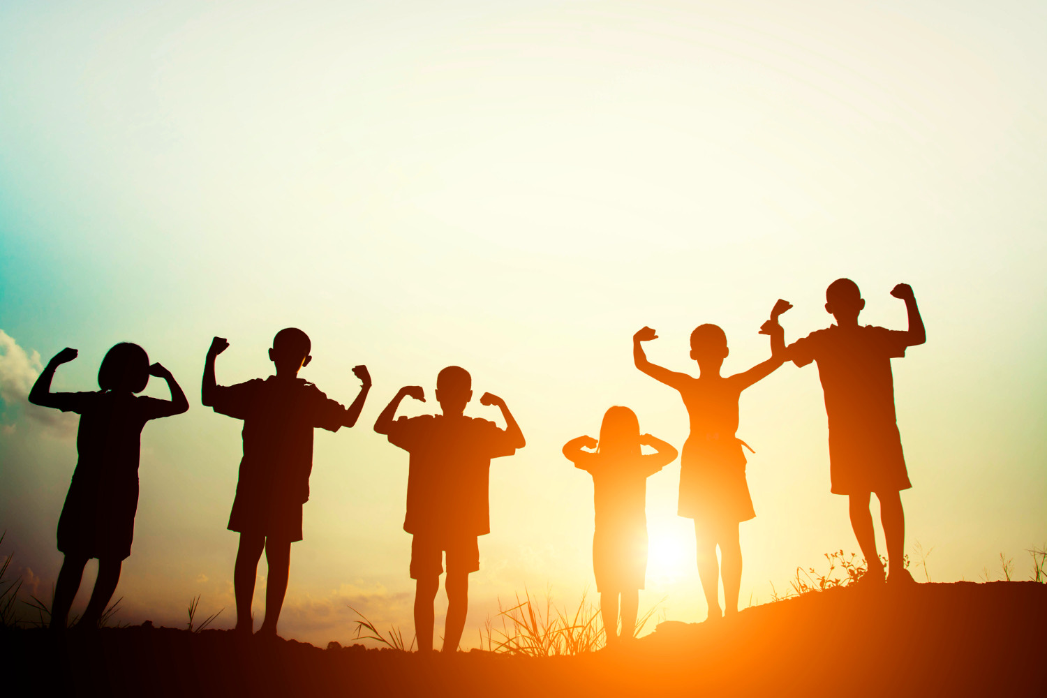 Children smiling together outdoors at sunrise